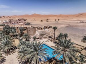 vista aerea della piscina con le palme e le dune sullo sfondo